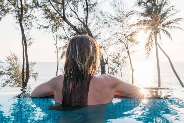 istock Woman Relaxing in Infinity Pool with Ocean View 2189494466