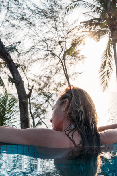 istock Woman Relaxing by Tropical Pool with Ocean View 2189494510