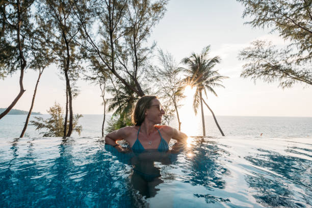 istock Woman Relaxing in Infinity Pool with Ocean View 2189494654