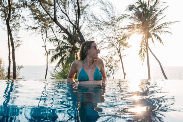 istock Woman Relaxing in Infinity Pool with Ocean View 2189494728