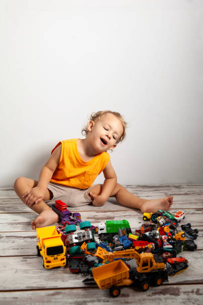 Boy playing with many toy cars