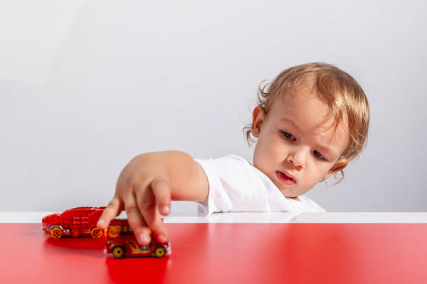Child playing with toy cars on track
