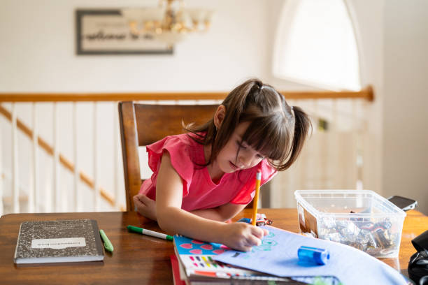 istock Girl doing the homework at the living room table 2189497728