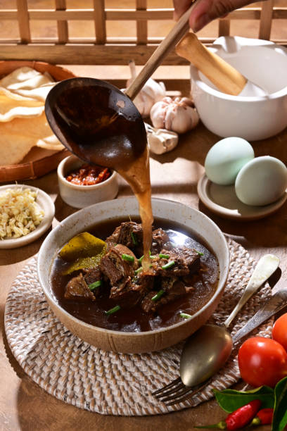 istock Rawon is a traditional Indonesian beef soup with a rich, black broth made from keluak nuts, aromatic spices, and herbs, typically served with rice and toppings like sprouts or sambal - selective focus 2189497755