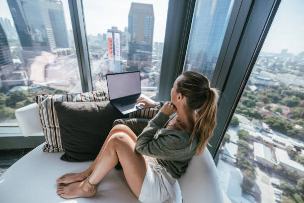 istock Focused Woman Using Laptop with City View 2189503174