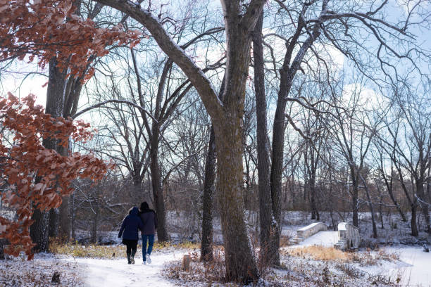 Newly engaged couple walk around Silver Lake on a cold snowy day in winter, Richester, Minnesota, USA