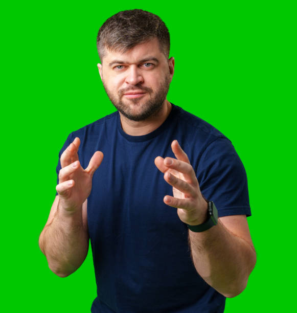 A man gestures with enthusiasm in front of a bright green background