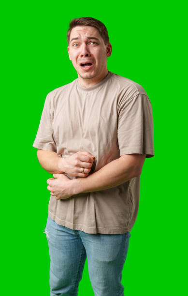 istock Man expressing fear while standing against a bright green background 2189513743