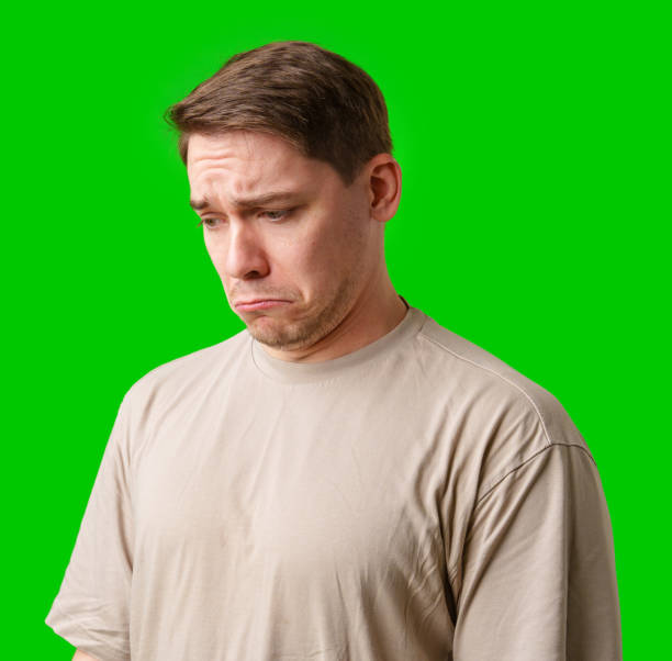 istock Man with a neutral expression poses against a bright green backdrop 2189513745
