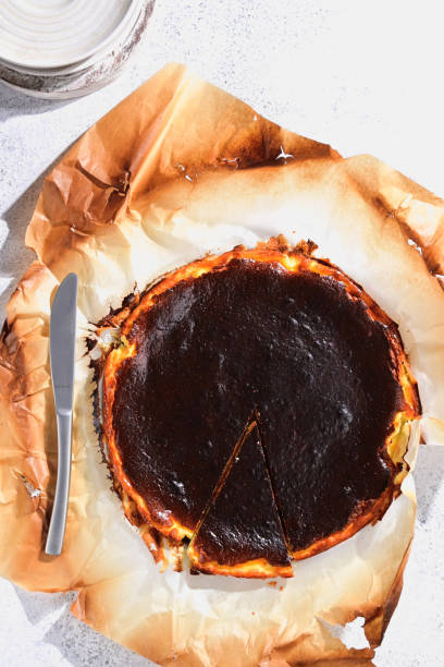 istock Basque burnt cheesecake placed on a textured white table - photographed from above (flat lay). 2189515423