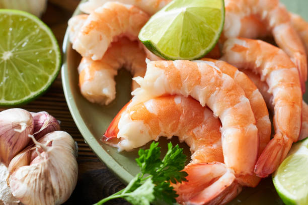 istock Shrimps with lime and parsley on a wooden table. 2189515952