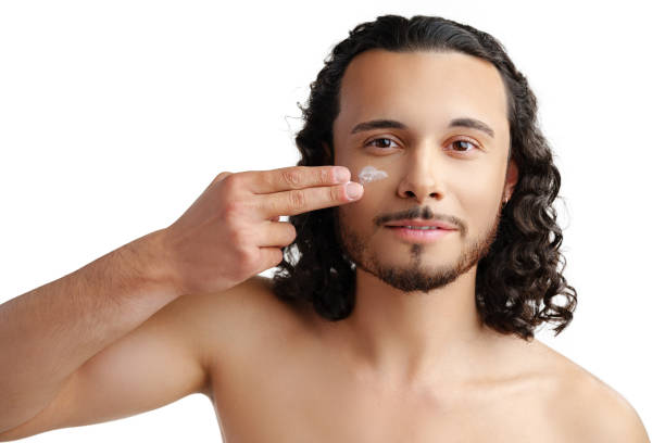 istock A young man demonstrates skincare routine with moisturizer on his face 2189517122