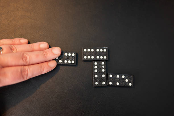 Businessman hand stopping the dominos falling