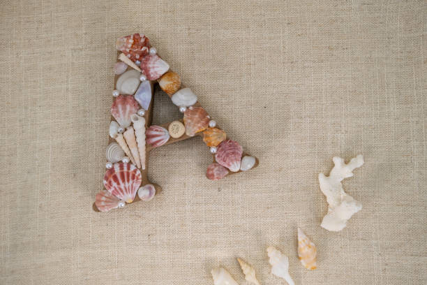 istock Seashell Letter A Flat Lay on Beige Fabric with Space for Custom Text 2189521250