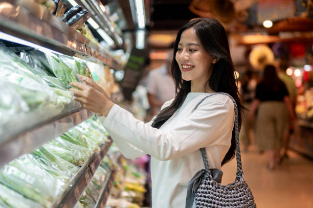 istock An attractive Asian woman selecting vegetables from a shelf while grocery shopping at a supermarket. 2189522409