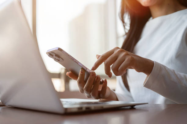 istock A close-up of a businesswoman touching her smartphone screen, using her smartphone while working. 2189522527
