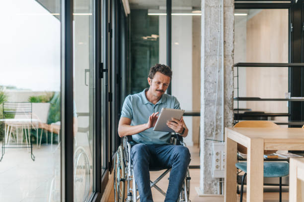 istock Man on a wheelchair working at the office 2189526573