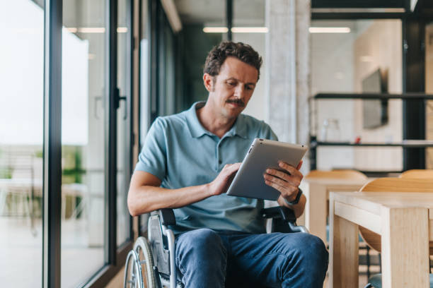 istock Man on a wheelchair working at the office 2189526575