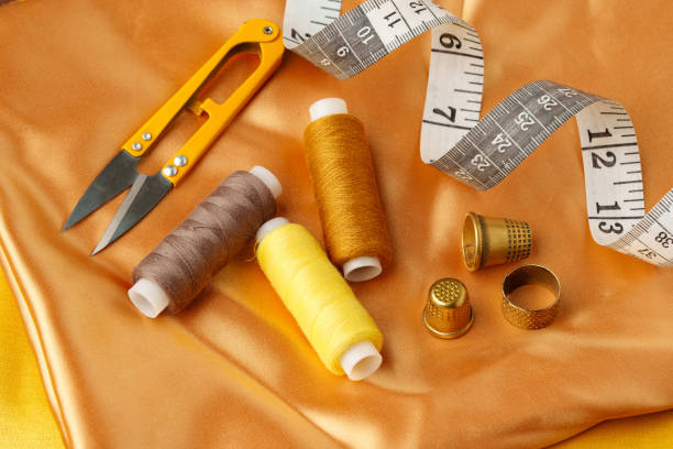 istock Sewing tools and materials arranged on a luxurious golden fabric background in a creative crafting workspace 2189526865