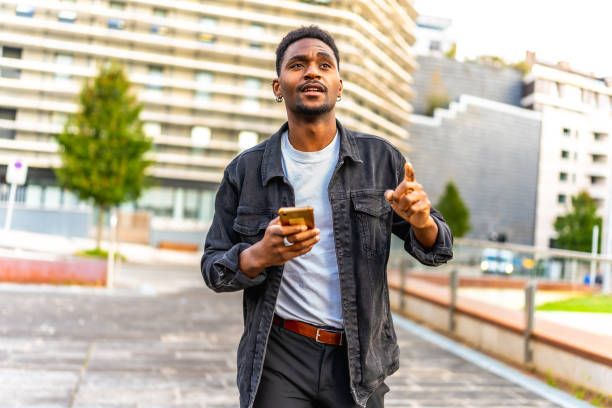 istock African man walking along the city using gps app 2189529379