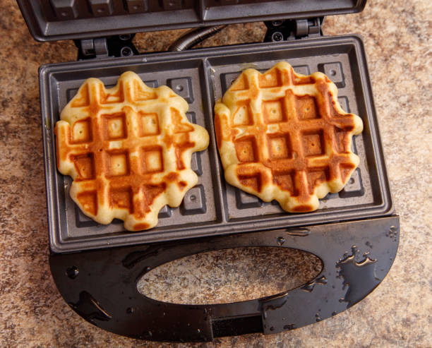 istock Two waffles are cooking in a waffle iron 2189529861