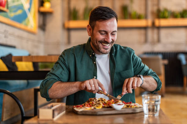 istock Man enjoying delicious pizza in stylish restaurant 2189533657
