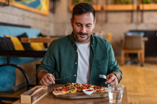 istock Man enjoying delicious pizza in stylish restaurant 2189533659
