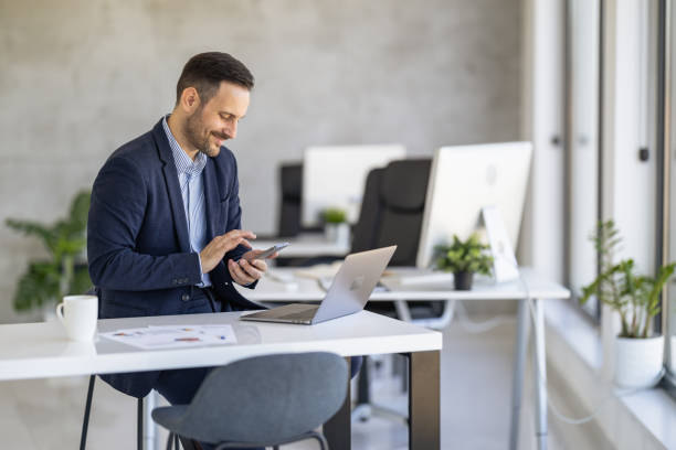 istock Professional Man Using Smartphone and Laptop in Modern Office 2189534789