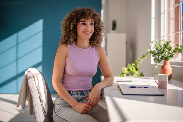 istock Young woman smiling while working at a bright and modern home office 2189535911