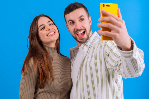 istock Couple taking a selfie together with a smartphone against a blue background. 2189536732