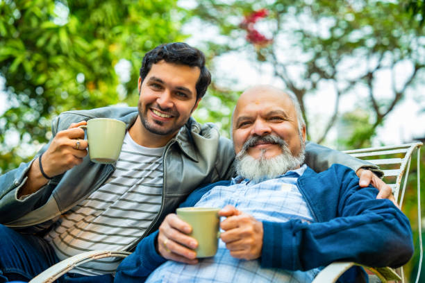 istock Father and son bonding outdoors, sitting together with coffee and sharing a lighthearted moment 2189537352