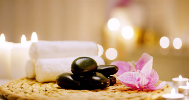 istock Spa, stone and candles with towels for massage as objects in desk for relaxation, luxury or stress relief for peace. Wellness center, resort and health salon for aromatherapy with zen or mindfulness 2189537879