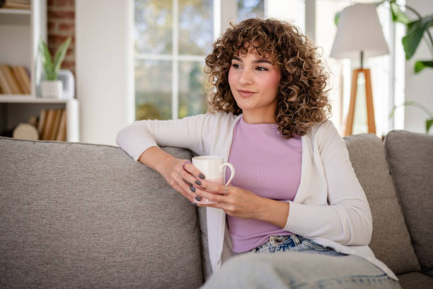 istock Relaxed woman enjoying a hot beverage at home with thoughtful expression 2189538247