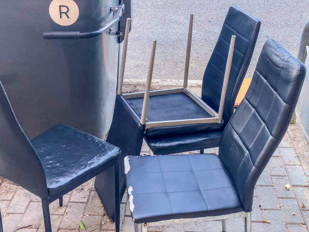 istock Set of chairs left next to garbage container in the street 2189539449