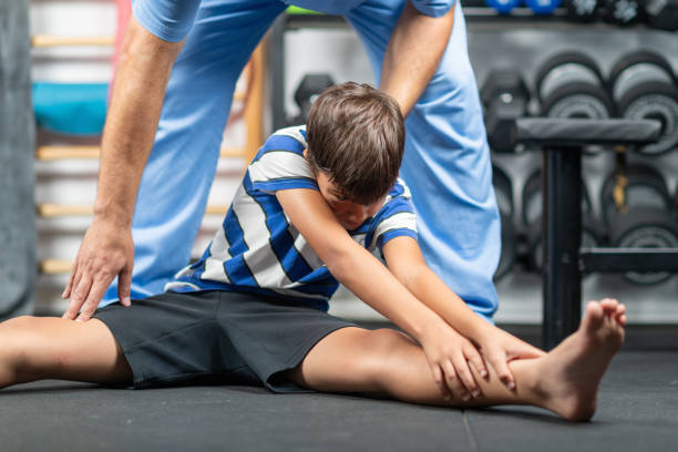 istock Physical therapist instructing a young boy in exercises, focusing on improving mobility, strength, and balance during a personalized rehabilitation session 2189541526