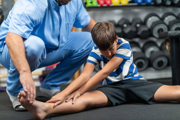 istock Physical therapist instructing a young boy in exercises, focusing on improving mobility, strength, and balance during a personalized rehabilitation session 2189541606