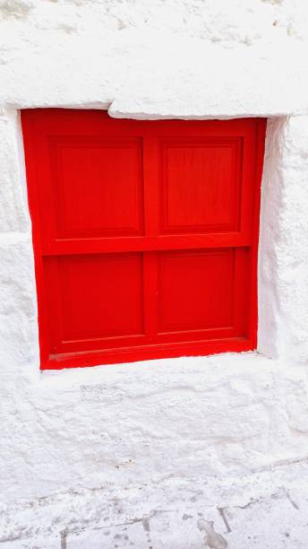 istock white exterior wall. red wooden shuttered window 2189546395