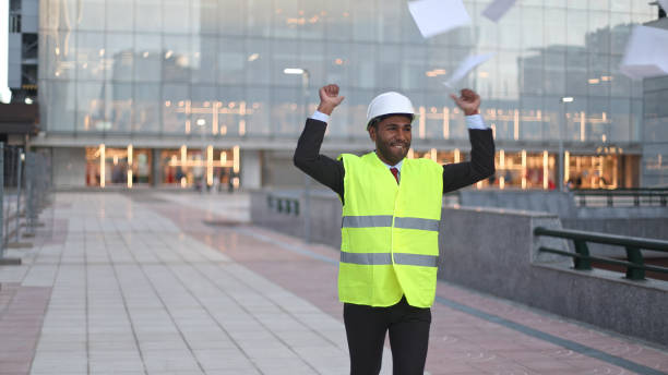 istock Happy architect throwing papers celebrating success in front of modern building 2189547363