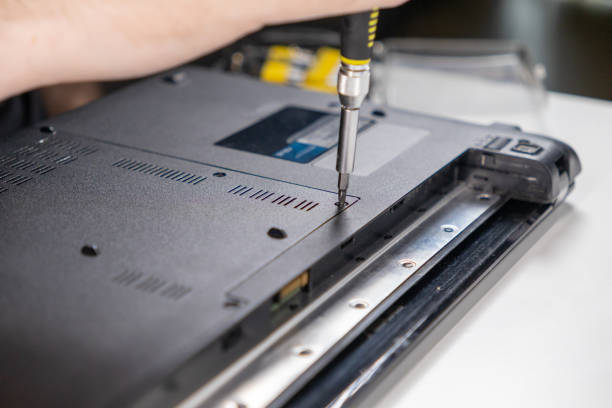 istock securing the back panel of a laptop with a screwdriver during reassembly, close-up of technician performing precise maintenance work 2189548262