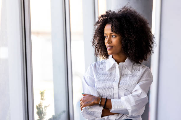 istock Confident Woman Standing by a Window in a Bright Modern Office 2189549075