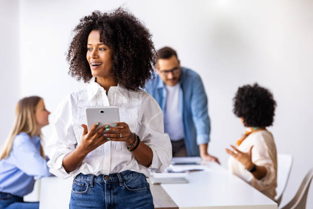 istock Young Professional Woman Holding Tablet in a Team Collaboration Setting 2189549078