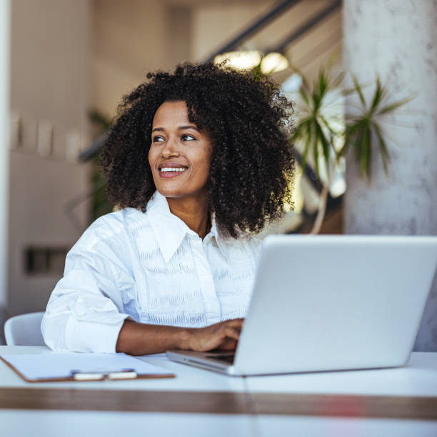 istock Confident Young Professional Smiling While Working on Laptop in Modern Office 2189549199