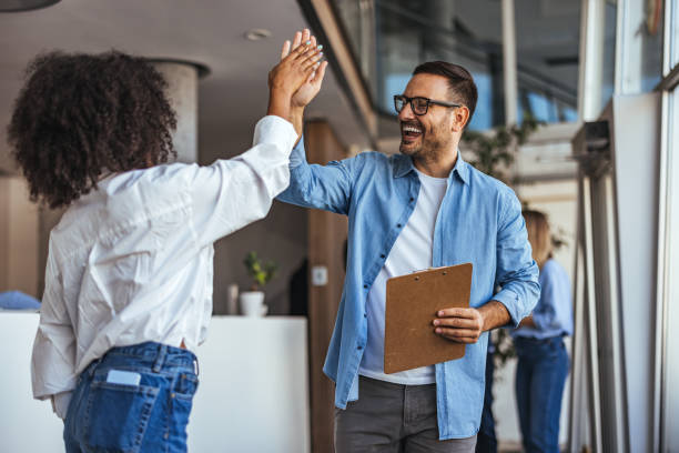 istock Cheerful Colleagues High-Fiving in Modern Office Setting 2189549670