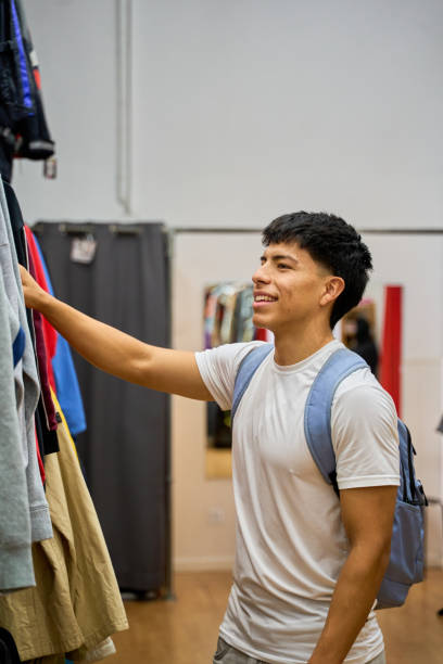 istock Young Latino man shopping for clothes in store 2189549711