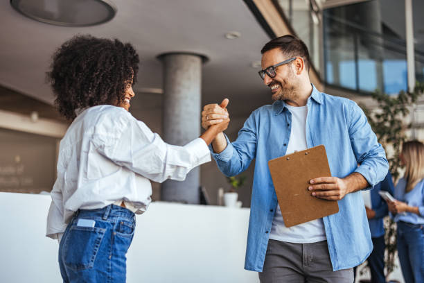 istock Office Coworkers Smiling and Shaking Hands in Modern Workplace 2189549728