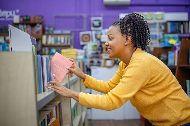 istock Woman Browsing Books in a Cozy Library Setting 2189550195