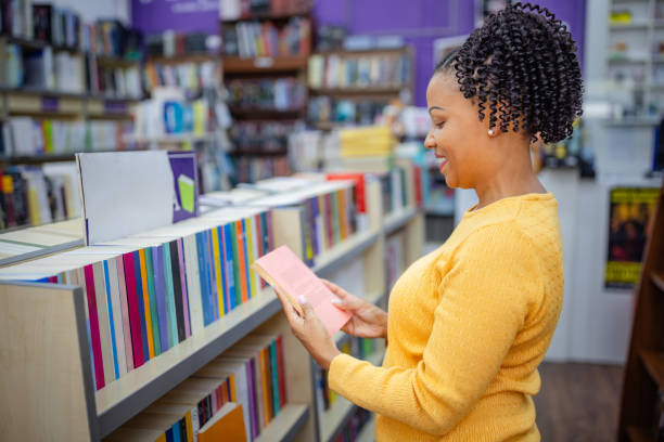 istock Woman reading a book in a vibrant bookstore setting 2189550280