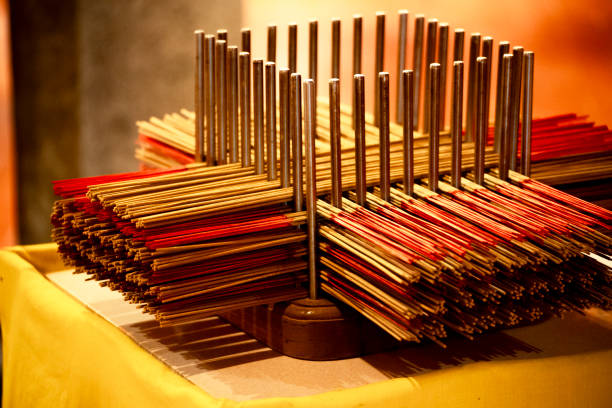 bundles of red incense sticks are neatly arranged on an iron rack