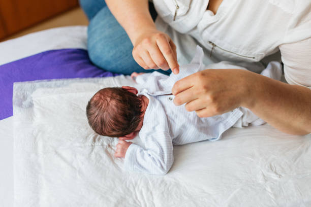 istock Mother dressing her newborn baby son on a changing mat 2189551416