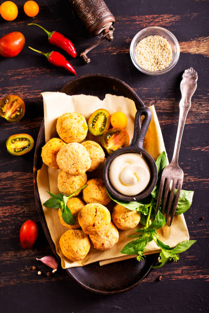 istock Fork with delicious falafel balls, sauce and vegetables on grunge background 2189551572